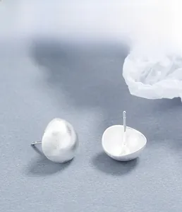 Macro view of minimalist 925 sterling silver studs with frosted semi-sphere texture