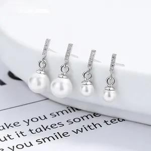 Macro detail of 925 silver pearl earrings with paved stone bars in two sizes