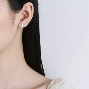Minimalist 925 sterling silver frosted ball stud earrings on female model's ear