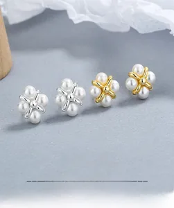 Detail view of flower-shaped S925 sterling silver pearl earrings in gold and silver