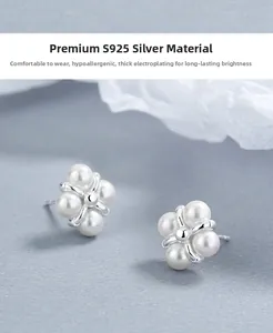 Macro shot of S925 sterling silver pearl stud earrings in a floral four-leaf design