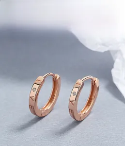Macro detail of S925 sterling silver hoop earrings with LOVE engraving and diamond