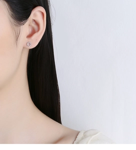 Detail view of 925 silver round zircon stud earring worn on ear for minimalist style