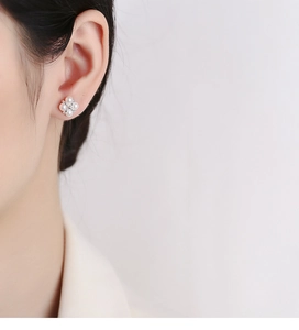 Close-up of pearl flower earrings on ear featuring elegant four-petal sterling silver design