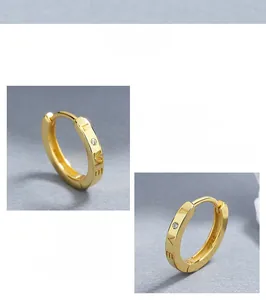 Macro shot of 925 silver gold-plated hoop earrings with LOVE engraving and zircon