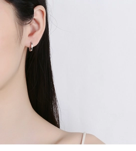 Close-up of minimalist S925 sterling silver hoop earrings worn on a female ear