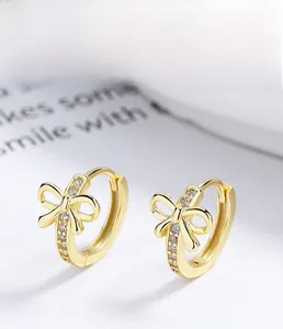 Dettaglio macro di orecchini a fiocco in argento 925 con pavé di zirconi cubici