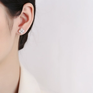 Elegant 925 sterling silver pearl flower stud earrings worn by a model in a minimalist style