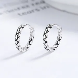 Macro shot of S925 sterling silver hoop earrings with engraved diamond lattice texture