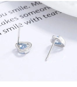 Gros plan de boucles d'oreilles en argent 925 avec zircons bleu clair en forme de cœur