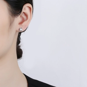 Élégante boucle d'oreille trèfle en argent 925 avec zircon portée sur le lobe