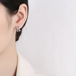 Sterling silver star hoop earrings with sparkling cubic zirconia on a model