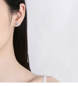 Close-up of 925 sterling silver anchor stud earring with zircon on model's ear