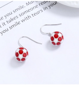 Detail of 925 silver soccer ball drop earrings with red and white enamel finish