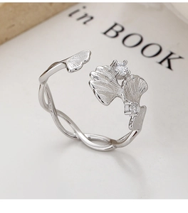 Macro d'une bague en argent 925 feuille de ginkgo avec cristaux sur fond de papier blanc