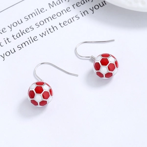 925 silver soccer earrings with red and white enamel texture on decorative book background