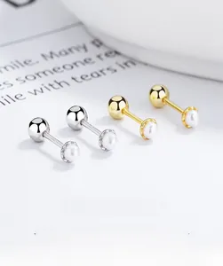 Detailed macro view of S925 silver and gold pearl stud earrings with screw backs