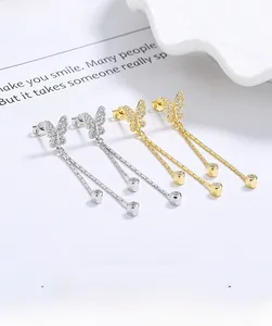 Detail of silver and gold butterfly tassel earrings with sparkling white zircons