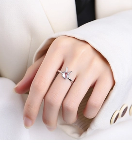 Detail of 925 sterling silver rabbit ring featuring a glowing moonstone on model's finger
