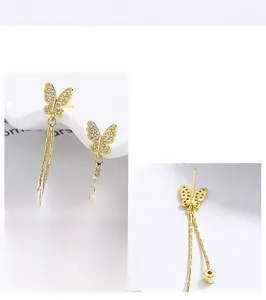 Macro view of gold 925 silver butterfly earrings with tassel and pavé zircon details
