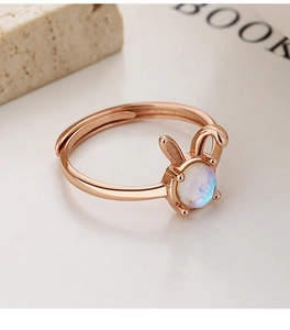 Close-up of rose gold bunny ring with iridescent moonstone and adjustable band