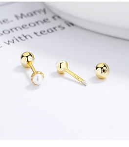 Macro shot of S925 silver pearl stud earring with screw ball back and gold finish