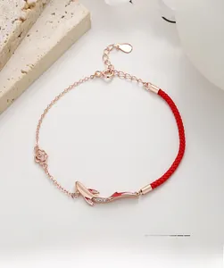 Detail of 925 sterling silver koi fish charm and red woven rope bracelet with rose flower