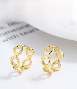 Dettaglio macro di orecchini a cerchio in argento 925 dorato con design a catena