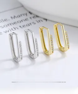 Detailed close-up of S925 silver and gold U-shaped hoop earrings with sparkling zircon inlay