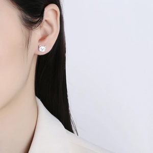 Orecchino a perno a forma di orsetto in argento 925 indossato da modella in stile minimal