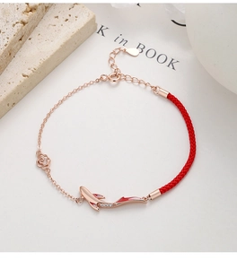 Detailed close-up of lucky koi carp pendant with red enamel and pavé zircons on red rope chain