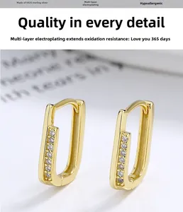 Macro detail of gold S925 sterling silver U-shaped earrings with rows of inlaid zircons