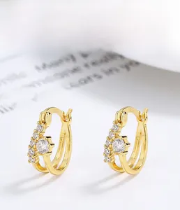 Détail macro de boucles d'oreilles en argent 925 doré avec zircones micro-incrustées