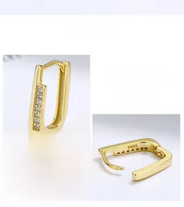 Macro shot of 925 silver U-shape gold earrings with pave cubic zirconia settings