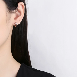 Pendientes de aro con garra de gato rosa en oro rosa lucidos por una modelo real