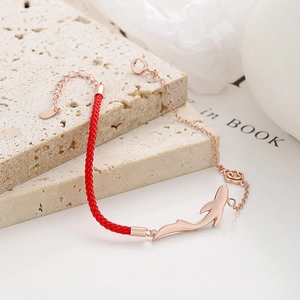 Lucky red string and rose gold chain bracelet with a polished dolphin pendant