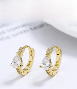 Macro detail of S925 sterling silver stamp on gold teardrop earrings with zircons