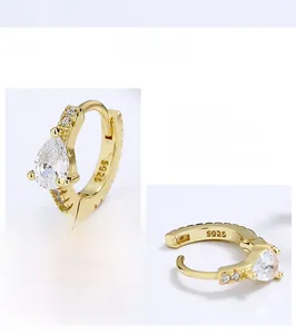 Detailed macro view of S925 sterling silver gold hoop earrings with pear-cut cubic zirconia