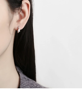 Close-up of 925 sterling silver drop earrings with pear-shaped stones on female model