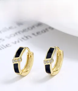 Détail de boucles d'oreilles en argent 925 avec émail noir et petites pierres de zircon