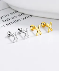Gros plan sur les boucles d'oreilles X en argent sterling S925 dorées et argentées