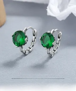 Macro shot of S925 sterling silver earrings with four-prong emerald green zircon stones