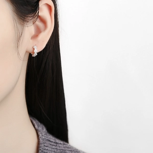 Orecchini a cerchio con rose in argento sterling S925 indossati da una modella su bianco
