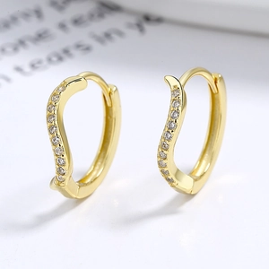 Golden S-shape hoop earrings with sparkling cubic zirconia on a minimalist background