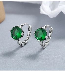 Macro shot of 925 sterling silver hoop earrings with emerald green zircon and s925 stamp