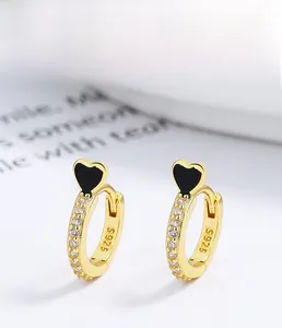 Macro shot of S925 sterling silver heart earrings with gold plating and pave setting