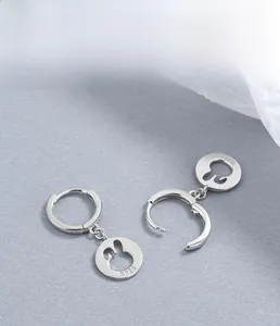 Macro detail of S925 sterling silver stamp and hollow rabbit silhouette earring charm