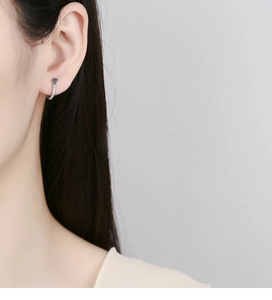 Detail of a 925 silver heart earring with black enamel and micro-set sparkling diamonds
