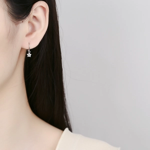Boucles d'oreilles étoile en argent 925 avec zircon portées par un mannequin femme