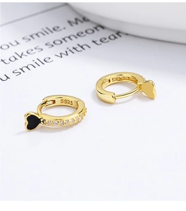 Macro shot of gold S925 silver heart earrings with row of zircons and black enamel
